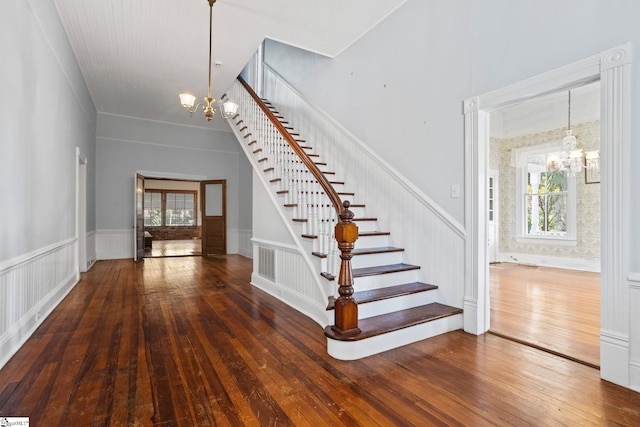 stairs with a notable chandelier and wood-type flooring