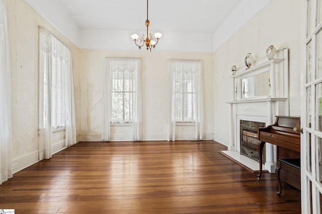 living room with a fireplace, dark hardwood / wood-style flooring, and an inviting chandelier