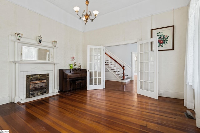 unfurnished living room with french doors, a chandelier, and dark hardwood / wood-style floors