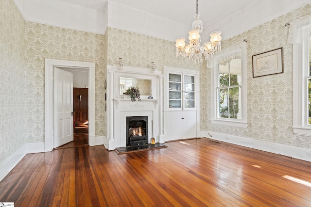 unfurnished living room featuring dark hardwood / wood-style floors and a chandelier