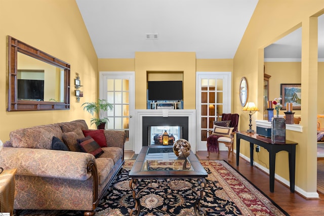 living room featuring hardwood / wood-style floors, vaulted ceiling, and ornamental molding