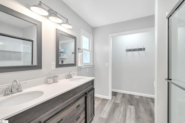 bathroom featuring hardwood / wood-style flooring, vanity, and walk in shower