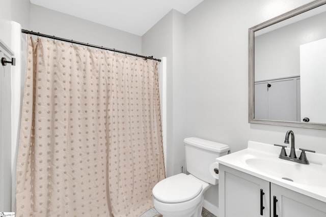 bathroom featuring vanity, curtained shower, and toilet