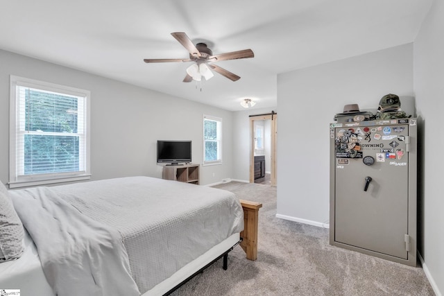 carpeted bedroom featuring stainless steel refrigerator, a barn door, ceiling fan, and multiple windows