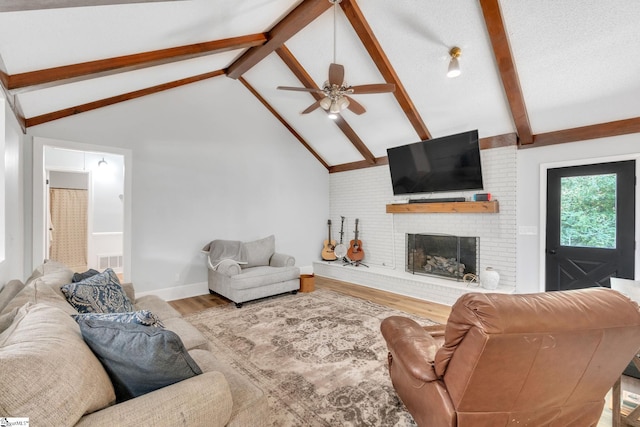 living room with a brick fireplace, ceiling fan, beam ceiling, high vaulted ceiling, and hardwood / wood-style floors