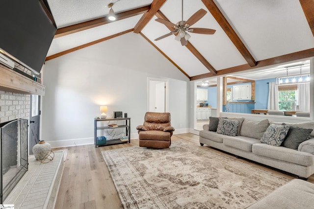 living room with beam ceiling, light wood-type flooring, high vaulted ceiling, and a brick fireplace