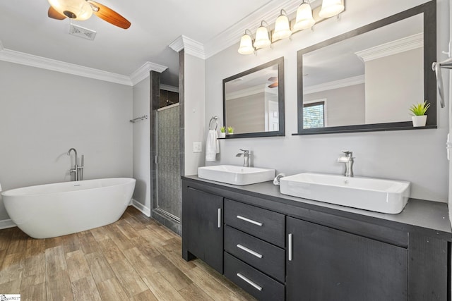 bathroom featuring wood-type flooring, vanity, separate shower and tub, and crown molding