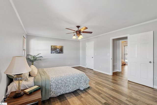 bedroom with multiple windows, hardwood / wood-style floors, ceiling fan, and crown molding