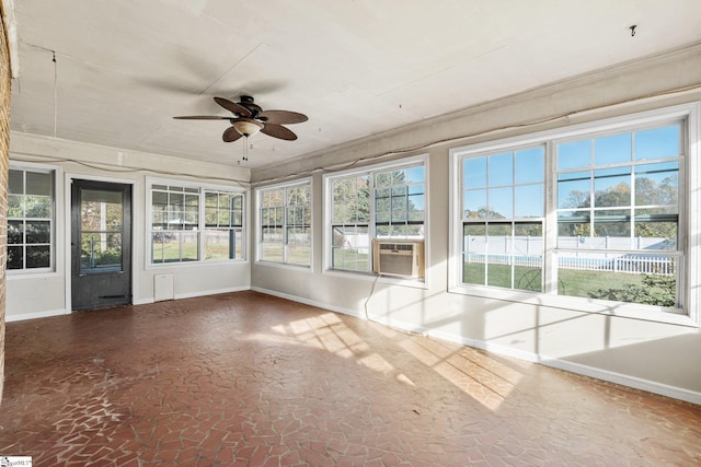 unfurnished sunroom featuring plenty of natural light, ceiling fan, and cooling unit