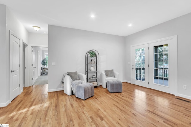 living area with a wealth of natural light and light hardwood / wood-style floors