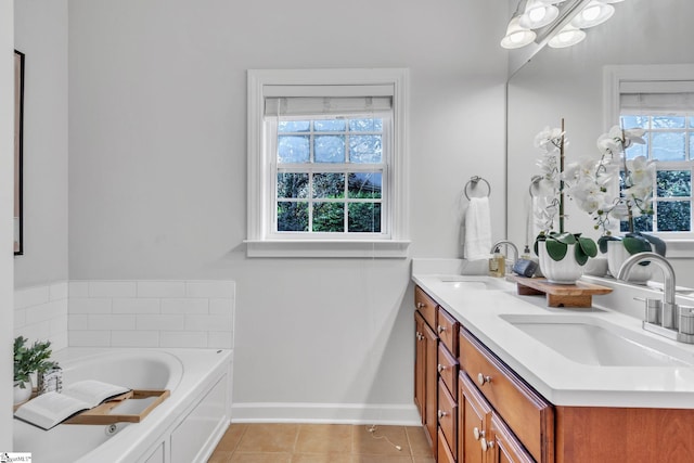 bathroom featuring tile patterned flooring, a bath, vanity, and a healthy amount of sunlight