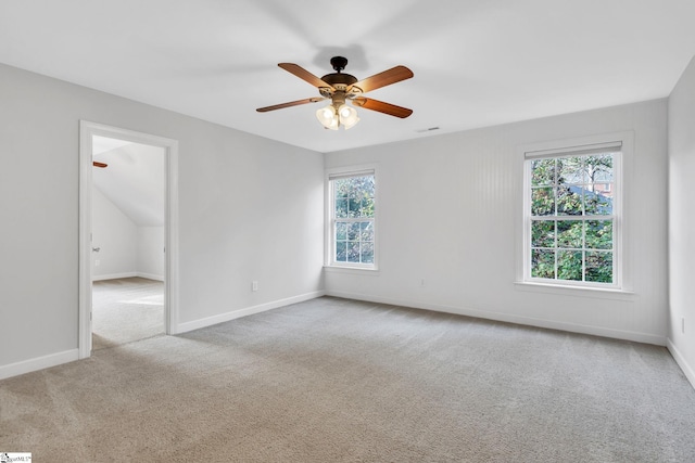 carpeted spare room with plenty of natural light and ceiling fan