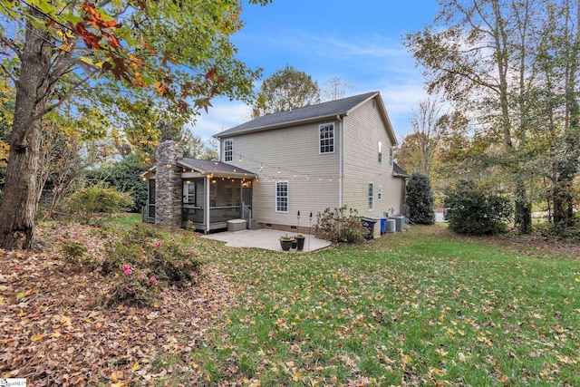 rear view of house with a sunroom, a patio area, and a yard