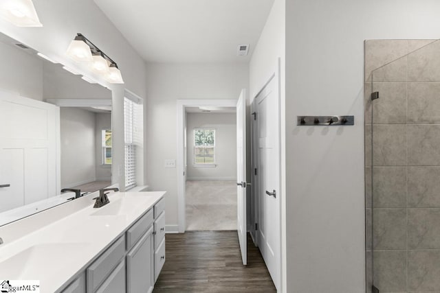 bathroom with wood-type flooring, vanity, and an enclosed shower