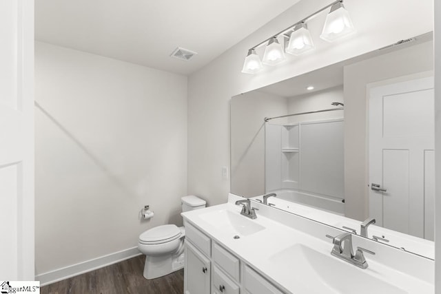 full bathroom with bathtub / shower combination, vanity, hardwood / wood-style flooring, and toilet