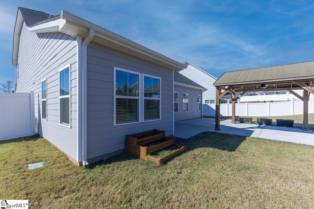 view of property exterior featuring a gazebo, a patio, and a lawn