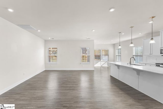 unfurnished living room with sink and dark wood-type flooring