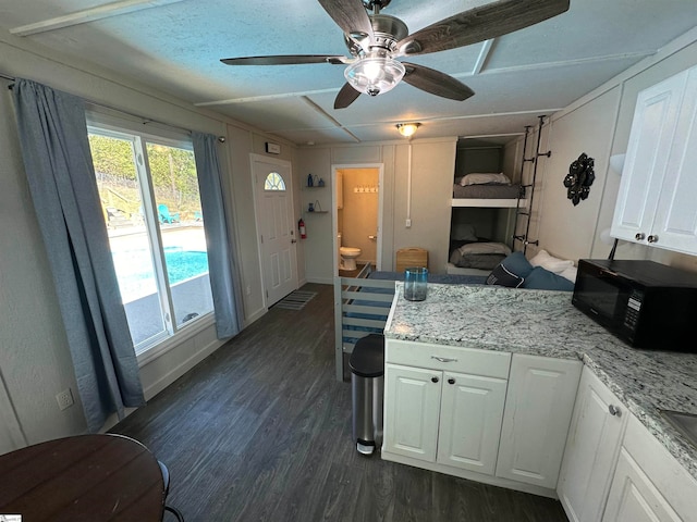 kitchen featuring ceiling fan, white cabinetry, and dark wood-type flooring