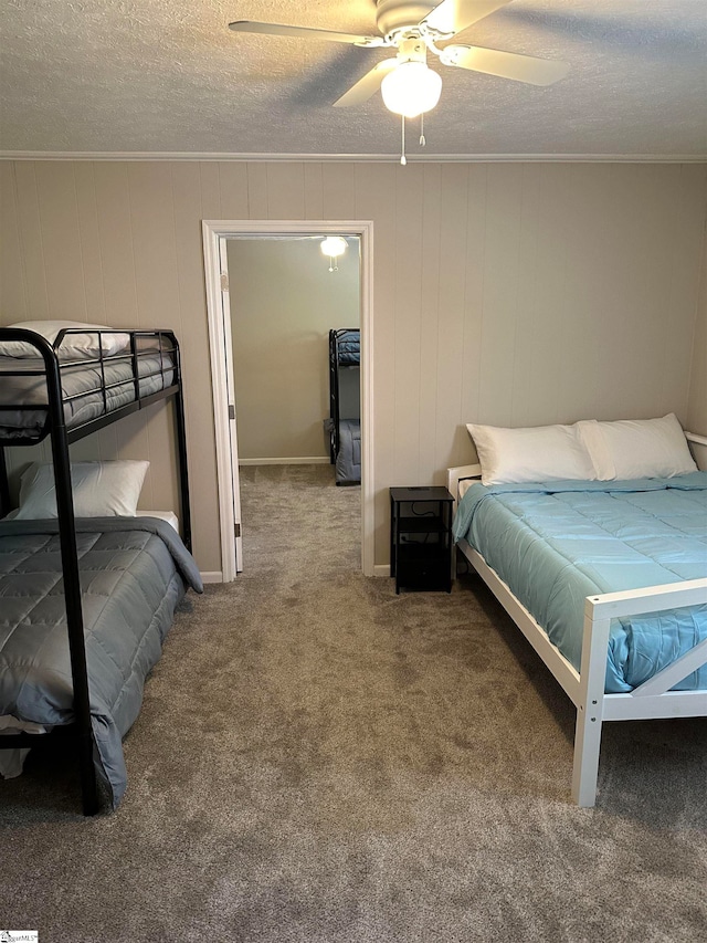 carpeted bedroom with ceiling fan, ornamental molding, and a textured ceiling