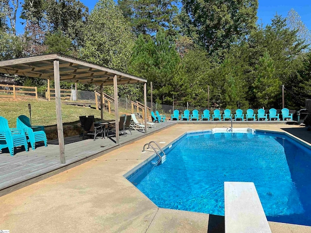 view of swimming pool with a diving board and a deck