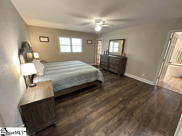 bedroom with a textured ceiling, ensuite bathroom, ceiling fan, and dark hardwood / wood-style floors