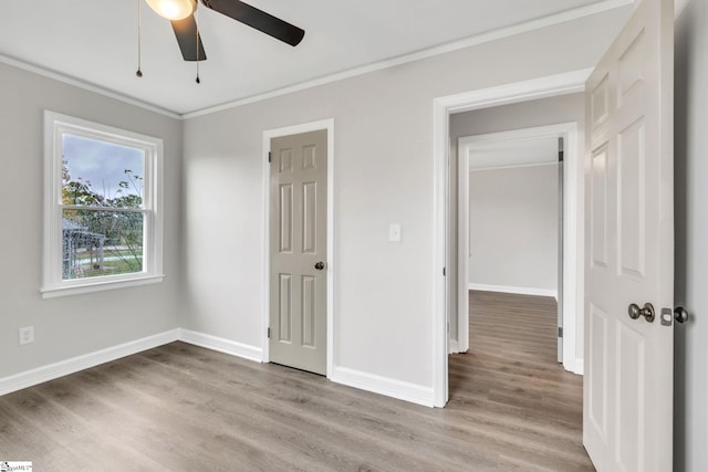 unfurnished bedroom featuring ceiling fan, light hardwood / wood-style floors, and crown molding