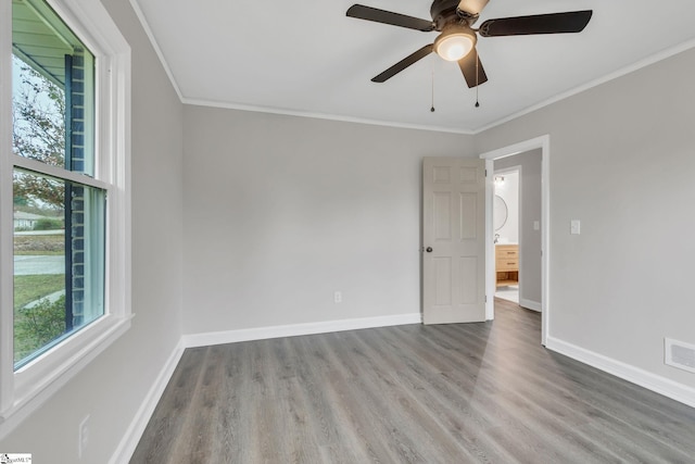 empty room with hardwood / wood-style flooring, plenty of natural light, and ornamental molding