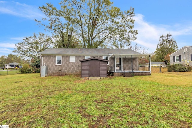 rear view of house featuring a storage unit and a lawn