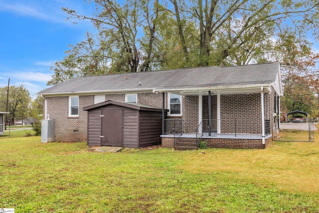 back of property with a storage unit and a yard