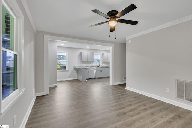 unfurnished living room featuring dark hardwood / wood-style floors, ceiling fan, ornamental molding, and sink