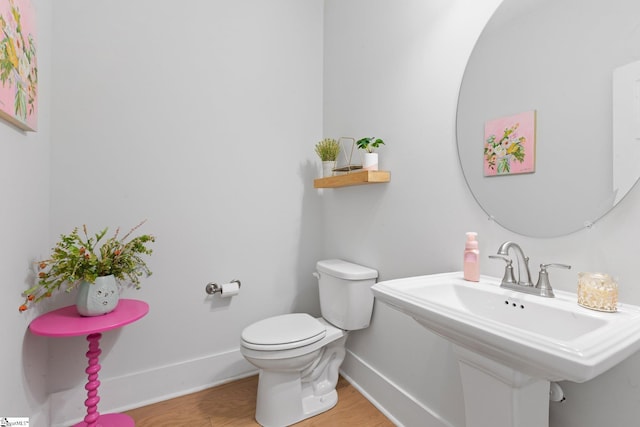 bathroom with hardwood / wood-style floors and toilet