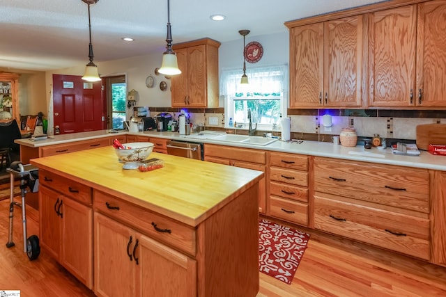 kitchen with a center island, sink, light wood-type flooring, tasteful backsplash, and kitchen peninsula