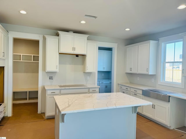 kitchen with white cabinetry, black electric stovetop, and a center island