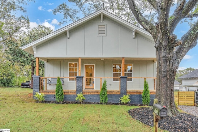 view of front of house with a porch and a front lawn