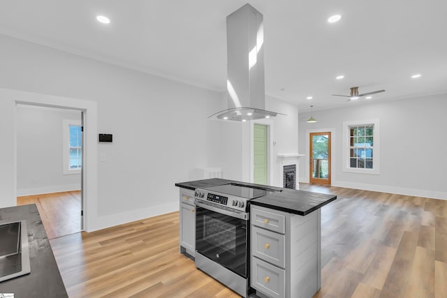 kitchen with island range hood, stainless steel range with electric cooktop, and light hardwood / wood-style flooring