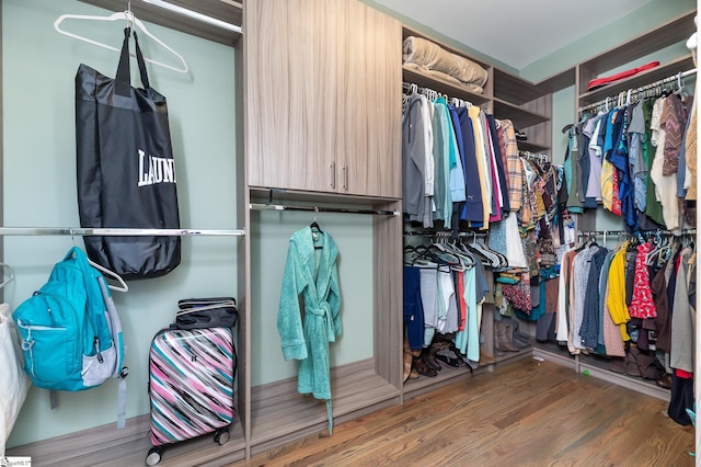 walk in closet with dark wood-type flooring