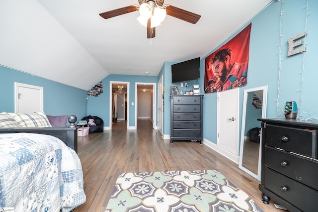 bedroom with hardwood / wood-style flooring, ceiling fan, and lofted ceiling