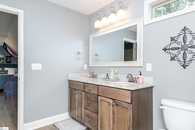 bathroom with wood-type flooring, vanity, and toilet