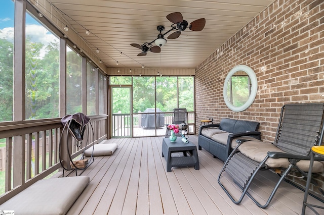 sunroom with ceiling fan and wooden ceiling