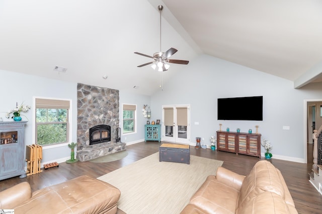 living room featuring high vaulted ceiling, dark hardwood / wood-style floors, a stone fireplace, and ceiling fan