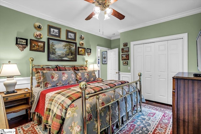 bedroom with hardwood / wood-style floors, ceiling fan, ornamental molding, and a closet