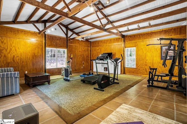 workout room with wood walls, plenty of natural light, and lofted ceiling