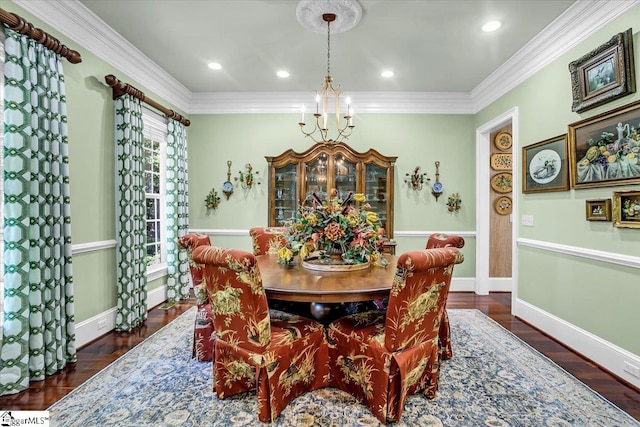 dining room with crown molding, dark hardwood / wood-style flooring, and an inviting chandelier