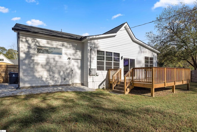 back of property with a yard and a wooden deck