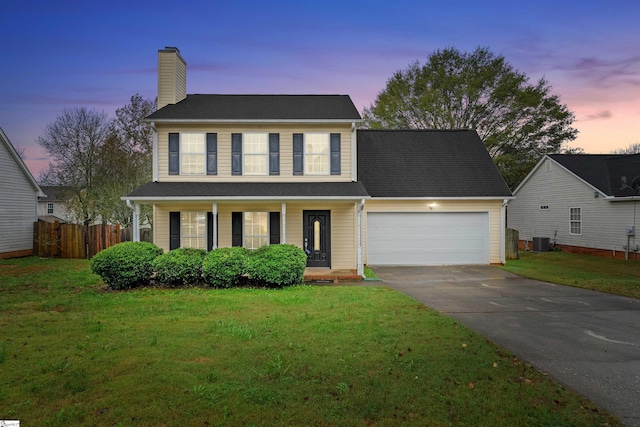 view of front of house with a yard, a garage, and cooling unit