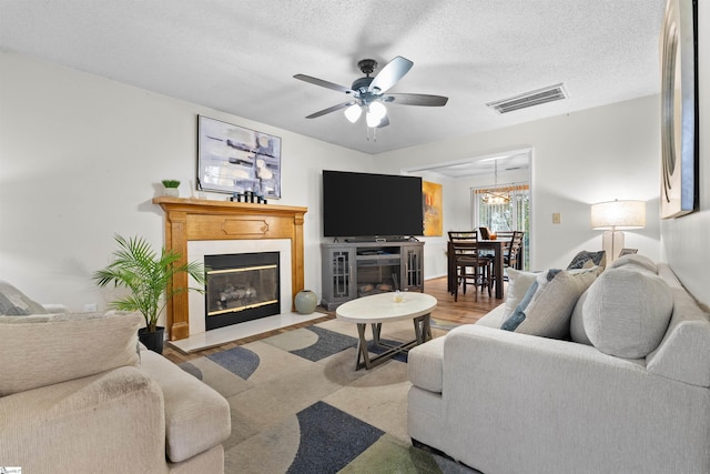 living room with ceiling fan and a textured ceiling