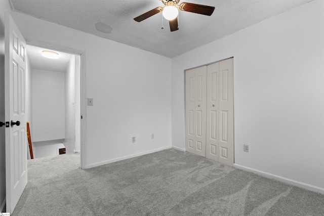 unfurnished bedroom featuring carpet, ceiling fan, a textured ceiling, and a closet