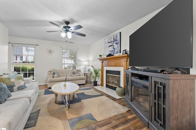 living room featuring a textured ceiling, dark hardwood / wood-style flooring, and ceiling fan