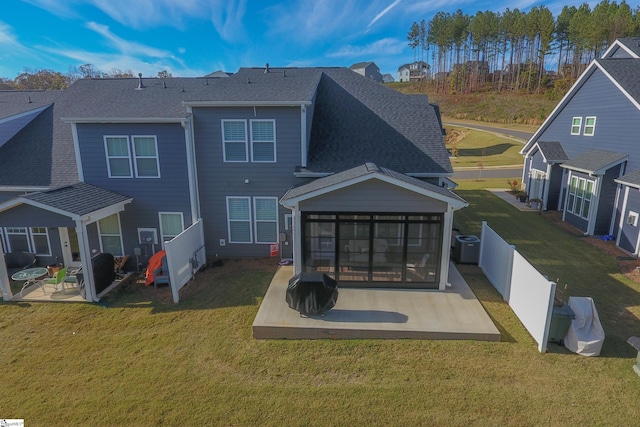 rear view of property with a yard, a patio, central air condition unit, and a sunroom