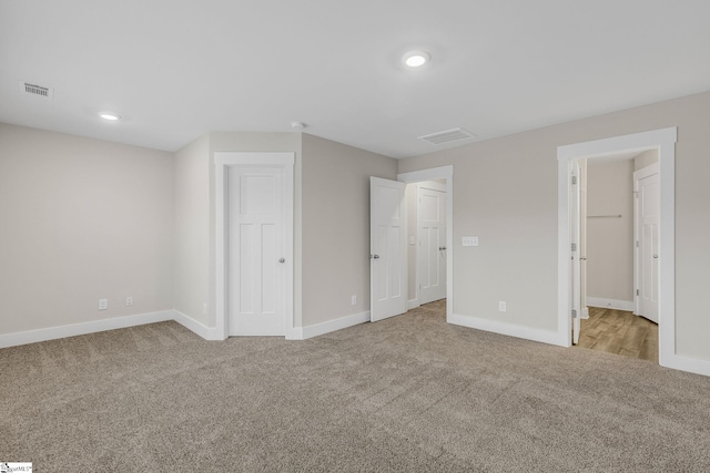 unfurnished bedroom featuring light carpet and a closet